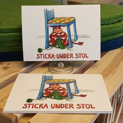Zoom bild av vykort ko under stol stickning